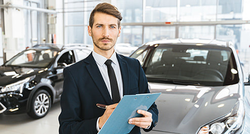 Car agent holding a folder and pen behind the cars photo